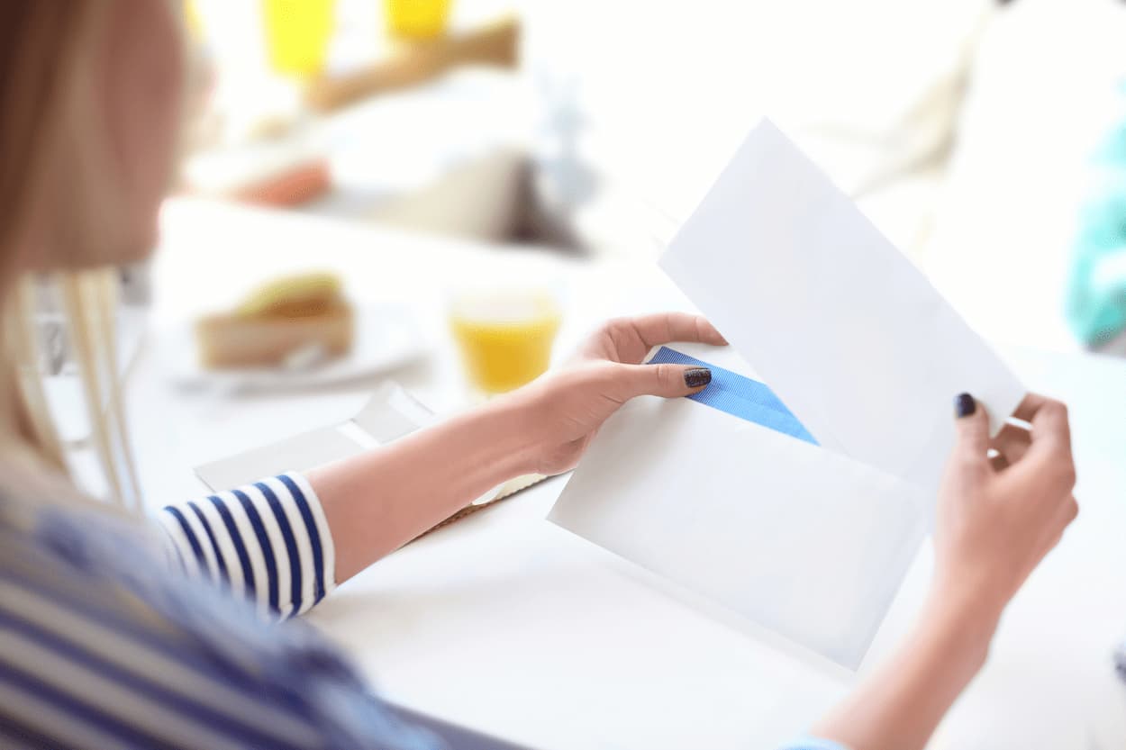 woman-inserting-mail-into-envelope